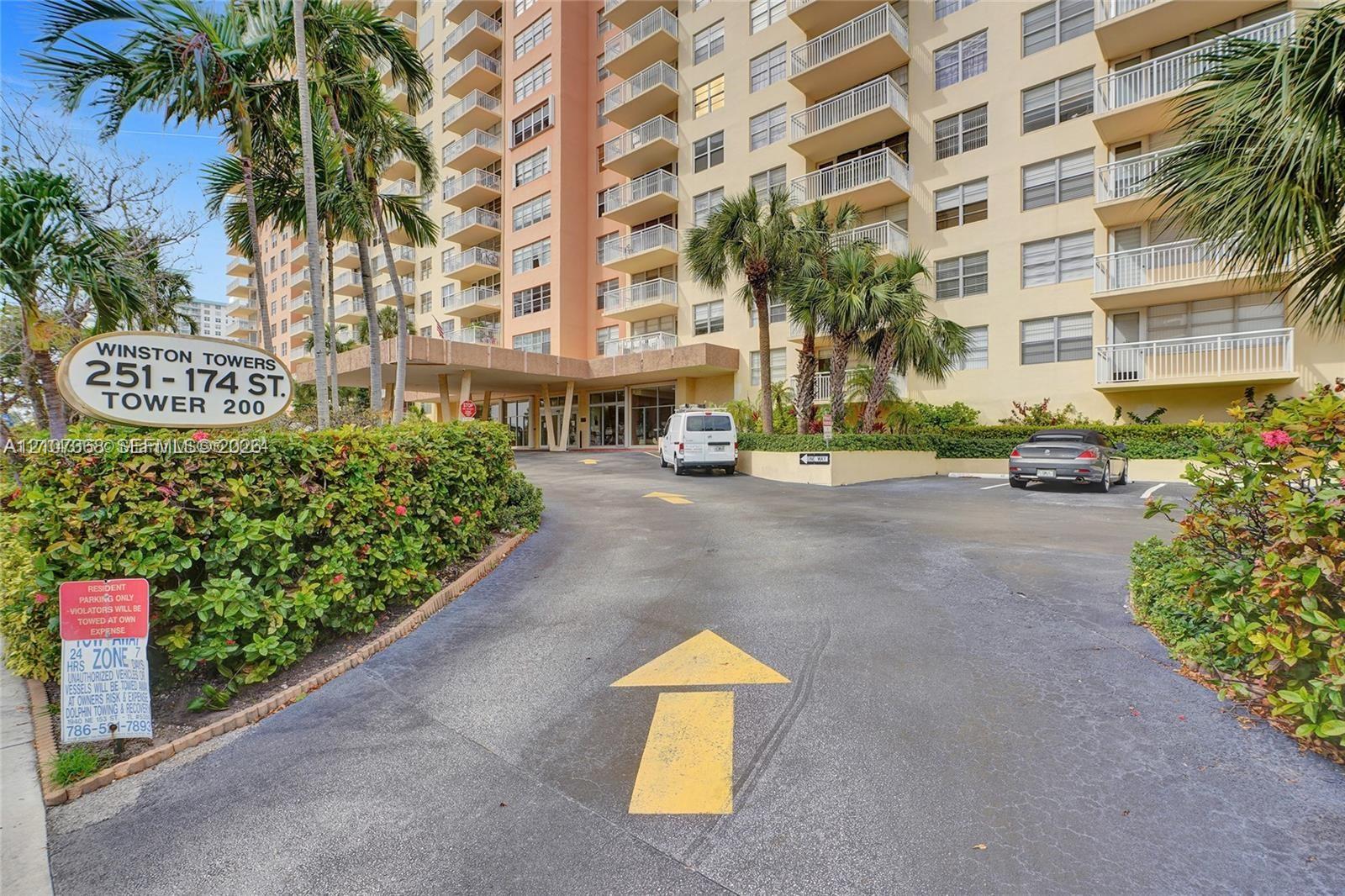 Multi-story residential high-rise featuring private balconies, a porte-cochere entrance, and mature palm landscaping
