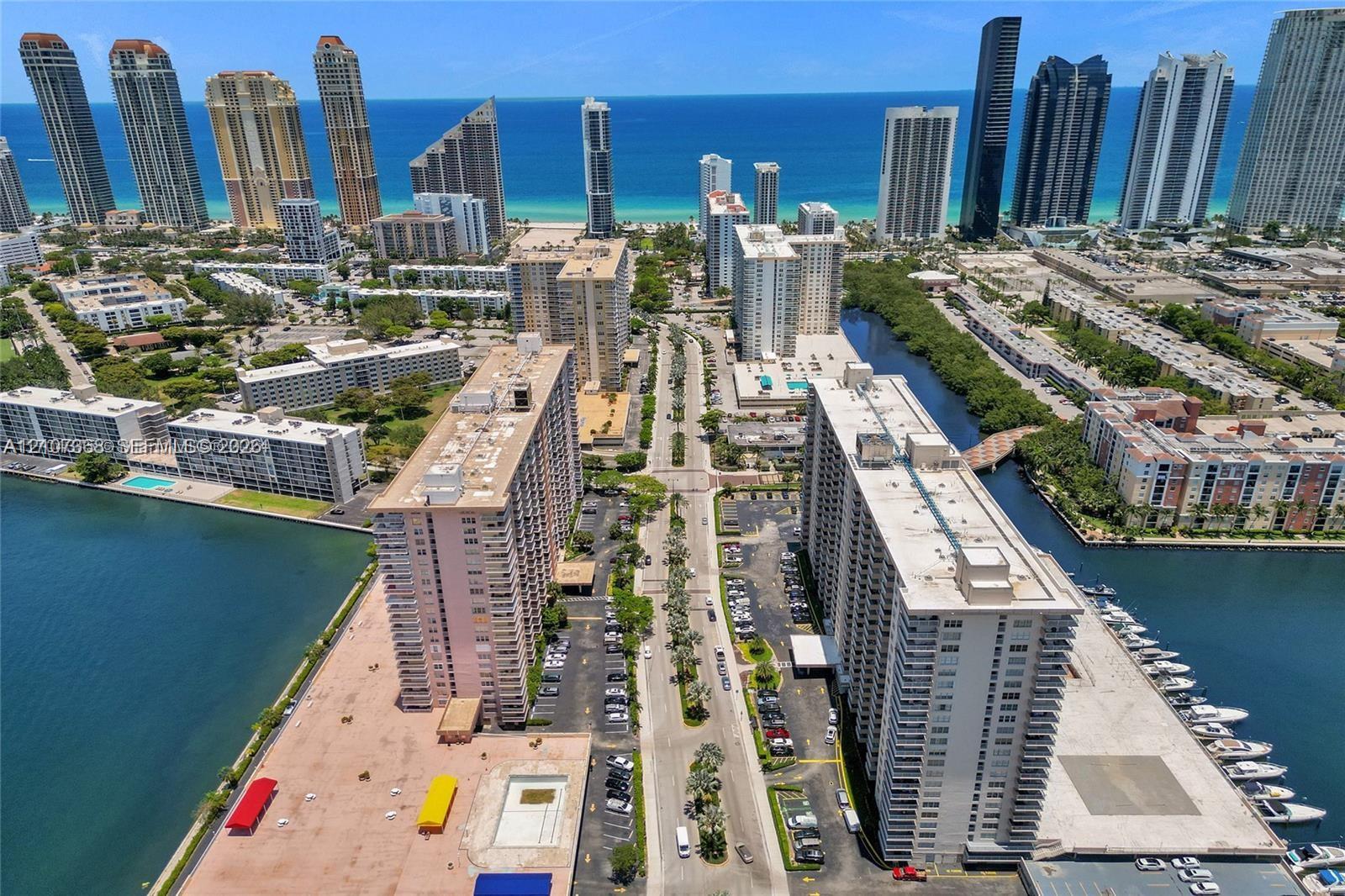 Aerial perspective of coastal high-rise properties featuring waterfront access, private boat slips, paved parking areas, and proximity to Atlantic coastline