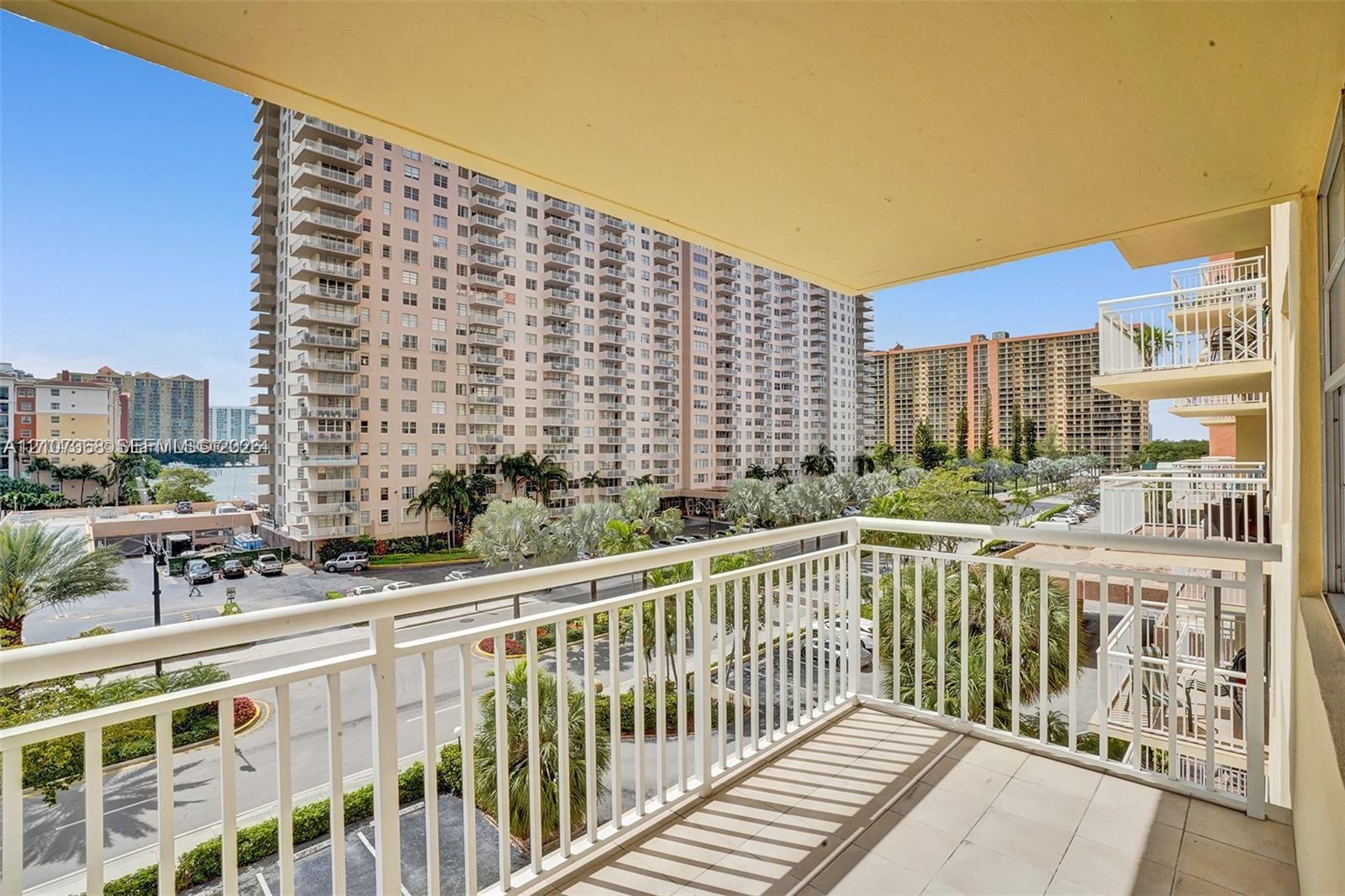 Covered private balcony featuring tile flooring and a vertical bar railing