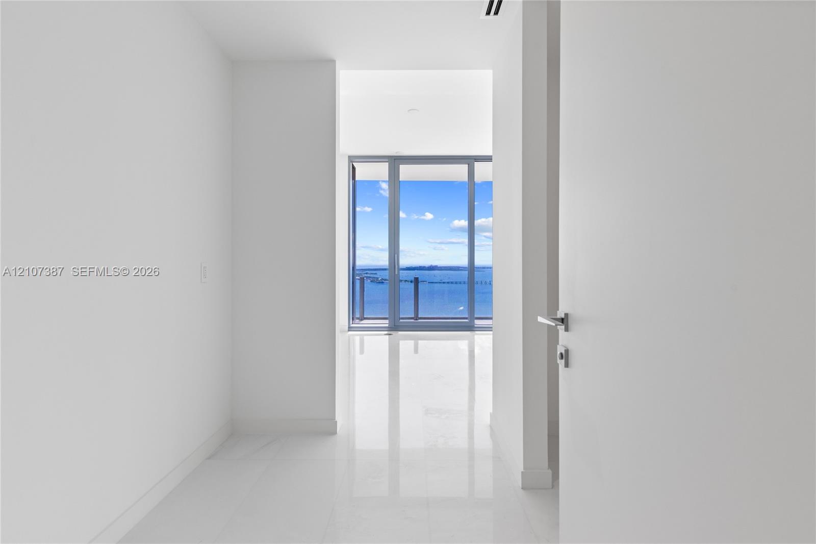 Polished stone flooring, floor-to-ceiling glass paneling, and expansive water scenery