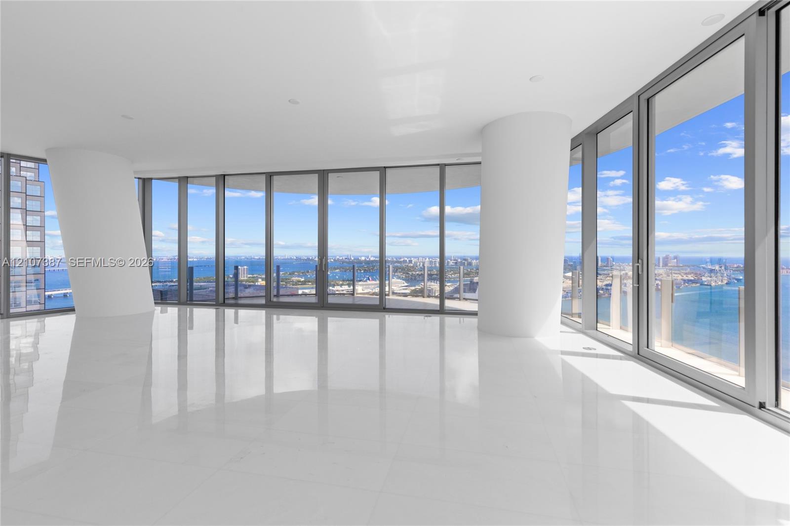 Floor-to-ceiling glass panel windows, stone-finish flooring, recessed lighting, and structural columns