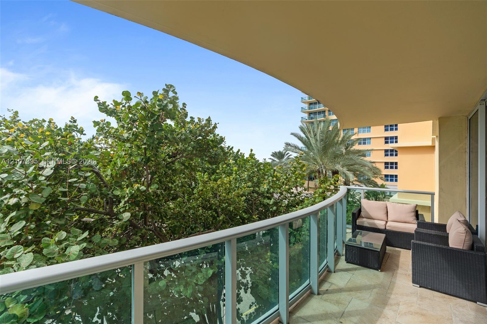 Covered terrace featuring stone tile flooring and a glass panel railing
