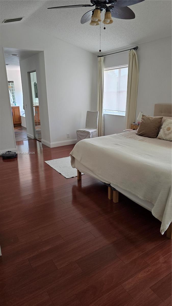 Wood-finish flooring, vaulted ceilings, and a ceiling fan with integrated lighting