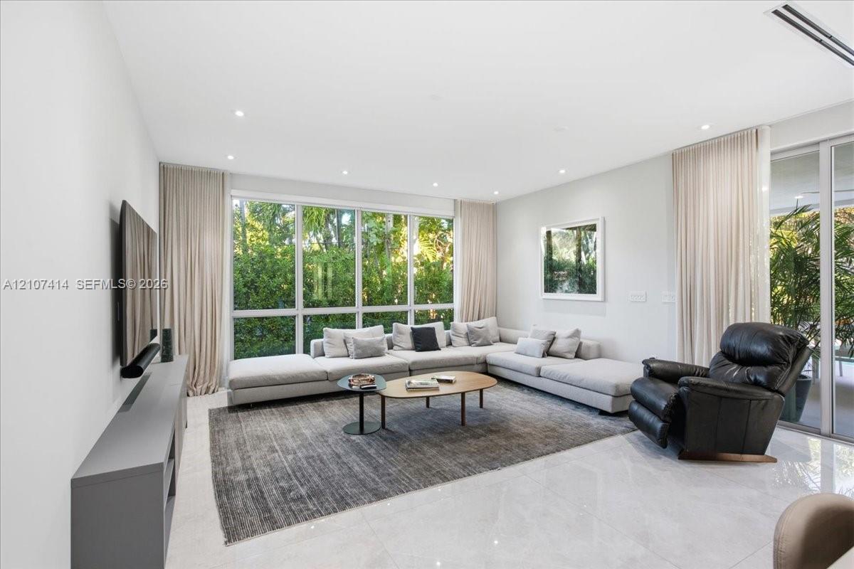 Floor-to-ceiling windows, polished stone flooring, recessed ceiling lighting, and floor-to-ceiling glass sliding doors