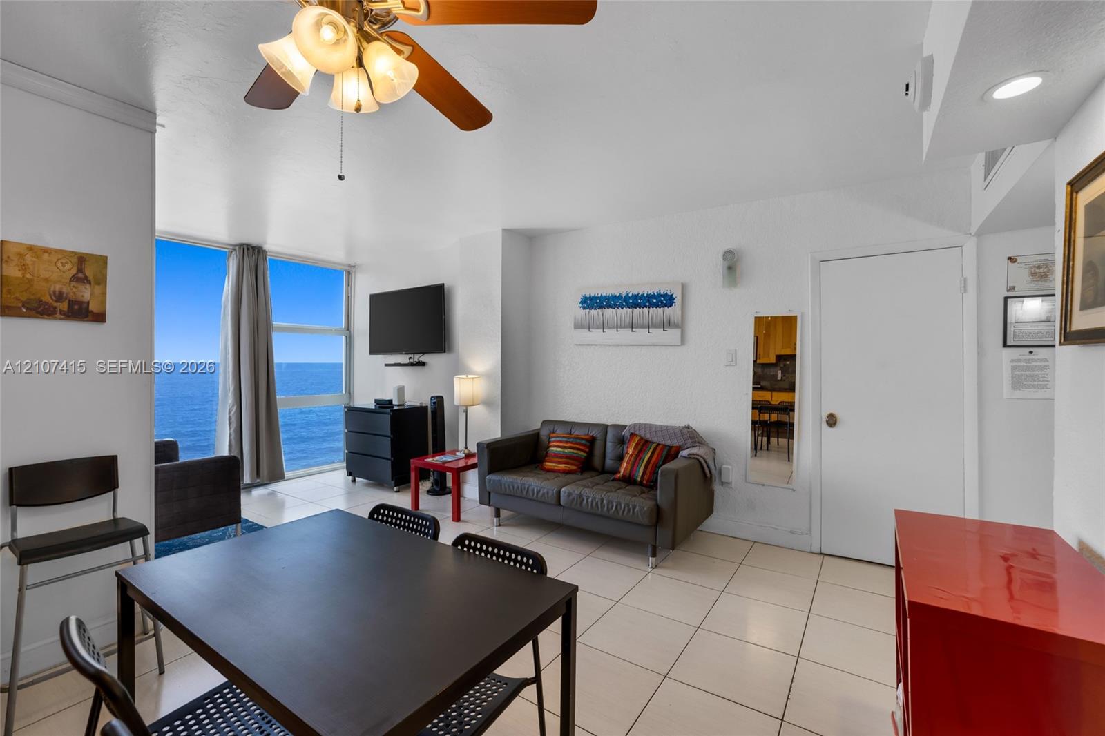 Floor-to-ceiling windows, tile flooring, and ceiling fan with integrated lighting