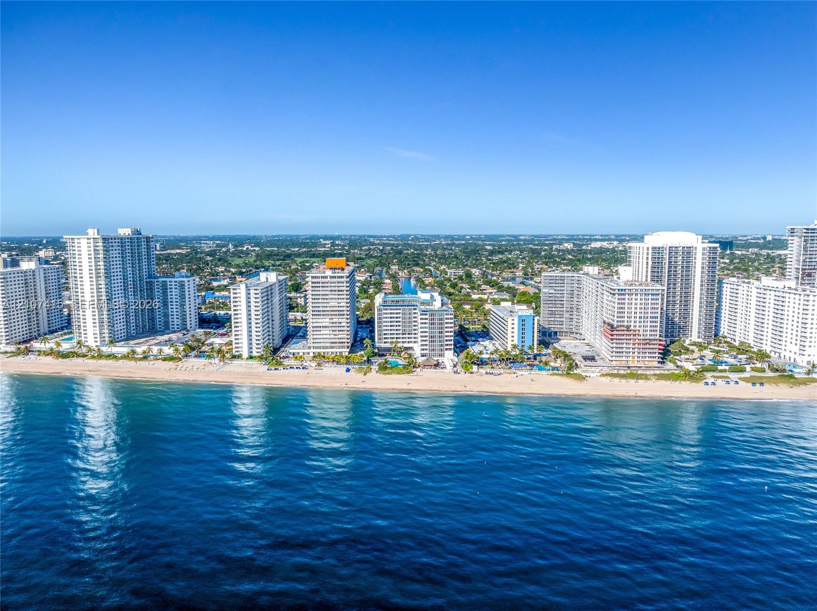 Coastal cityscape featuring high-rise architecture, direct shoreline access, and expansive ocean frontage