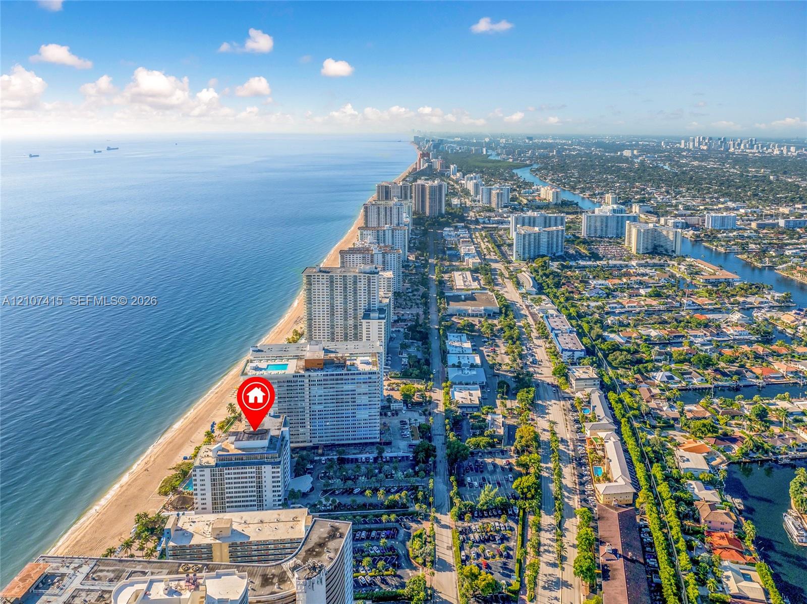 Aerial perspective of coastal high-rise development featuring direct oceanfront positioning and immediate proximity to the shoreline
