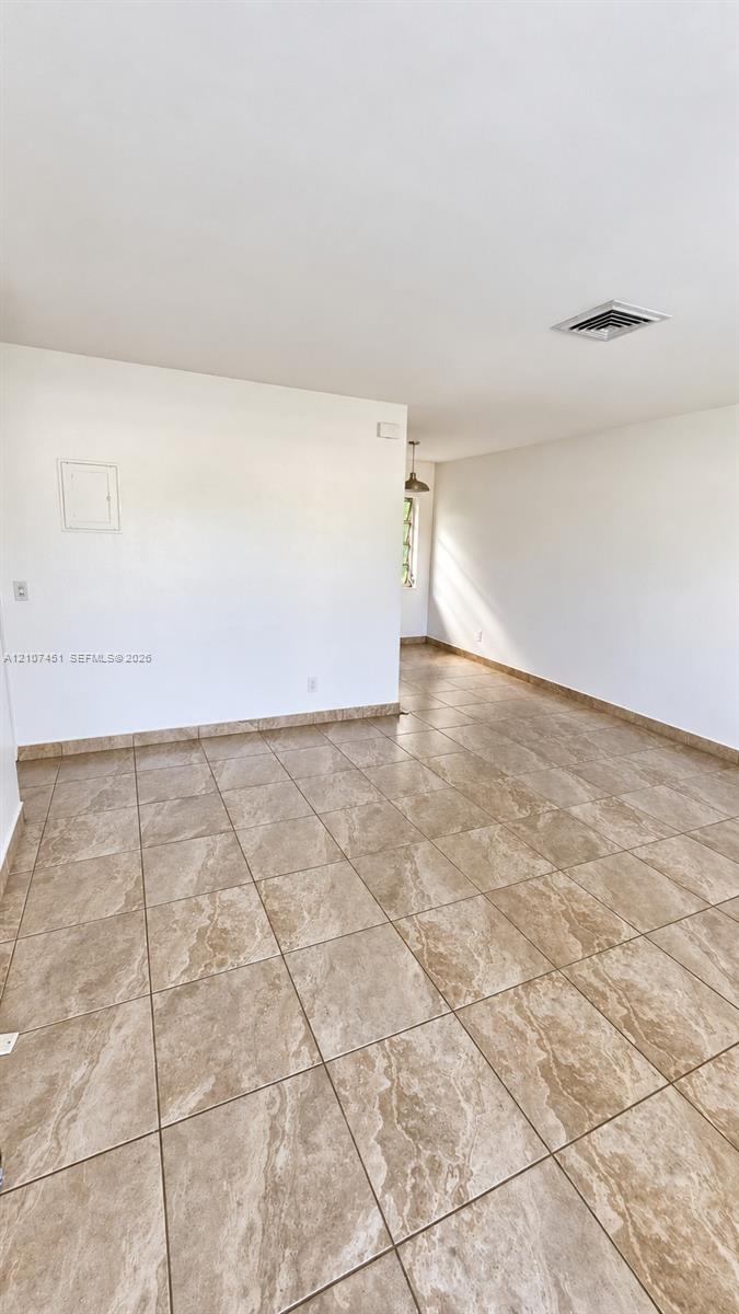 Open-concept interior space featuring large-format ceramic tile flooring with stone-pattern detail and neutral wall finishes Open-concept interior space featuring large-format ceramic tile flooring with stone-pattern detail and neutral wall finishes