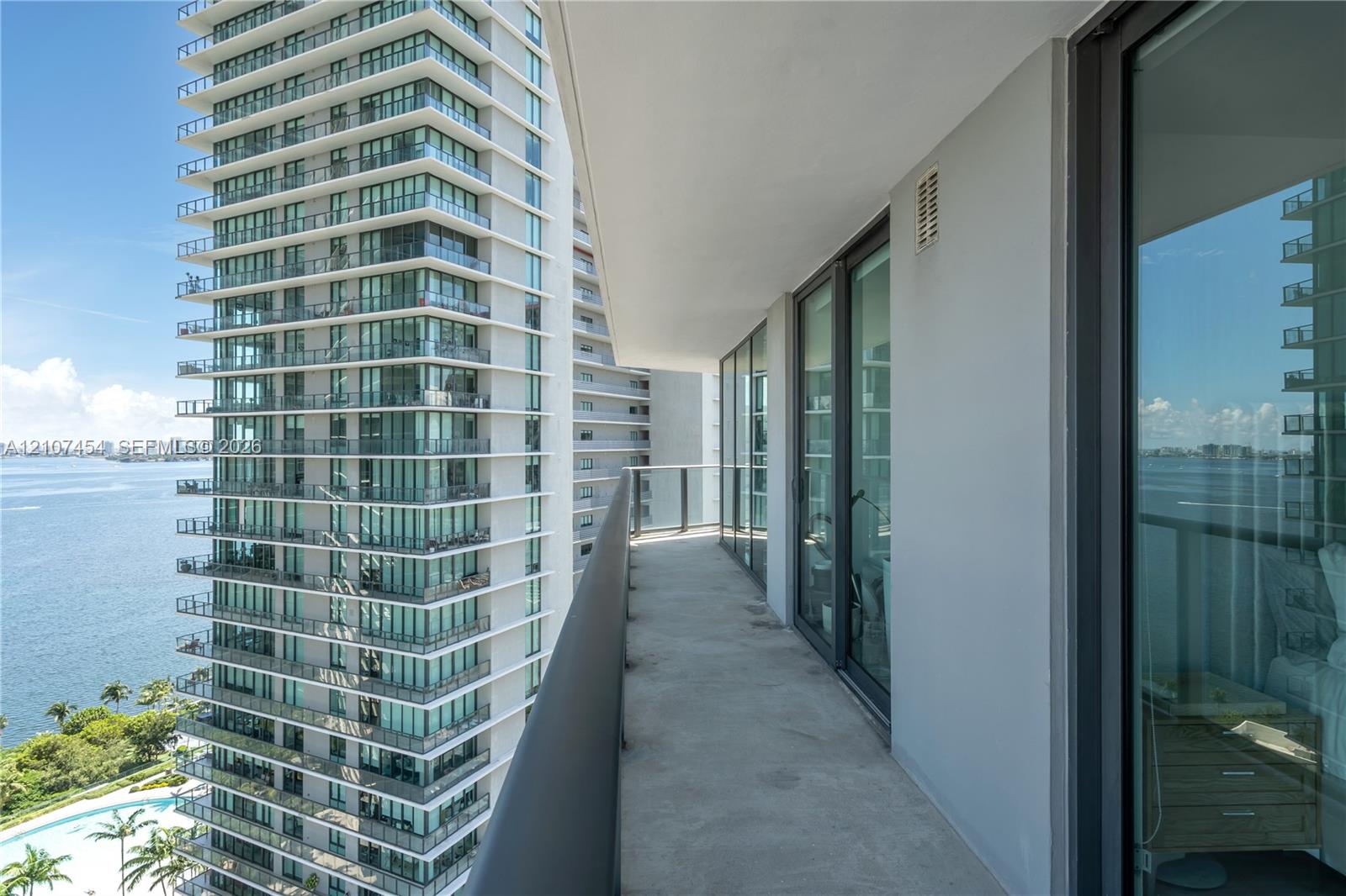 Covered balcony featuring glass railing and floor-to-ceiling sliding glass doors