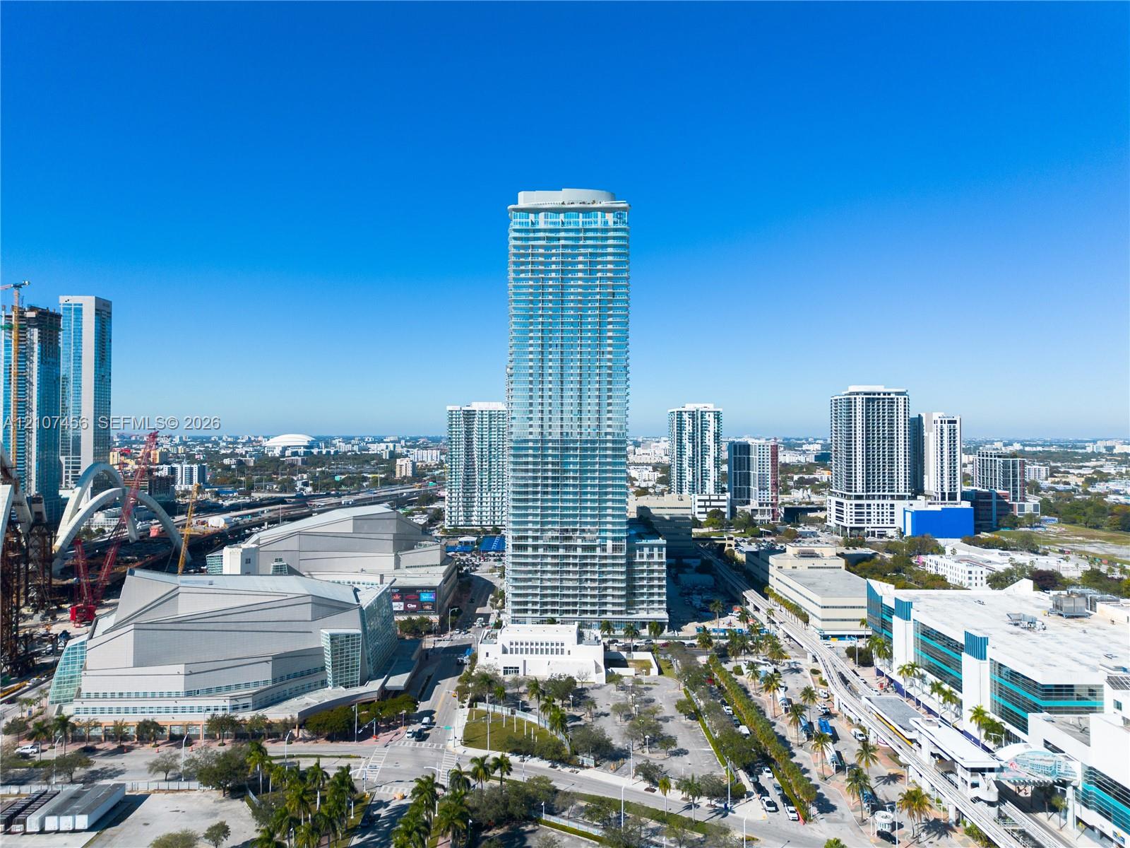 High-rise residential tower featuring a glass-curtain facade, wrap-around balconies, and a multi-level architectural design