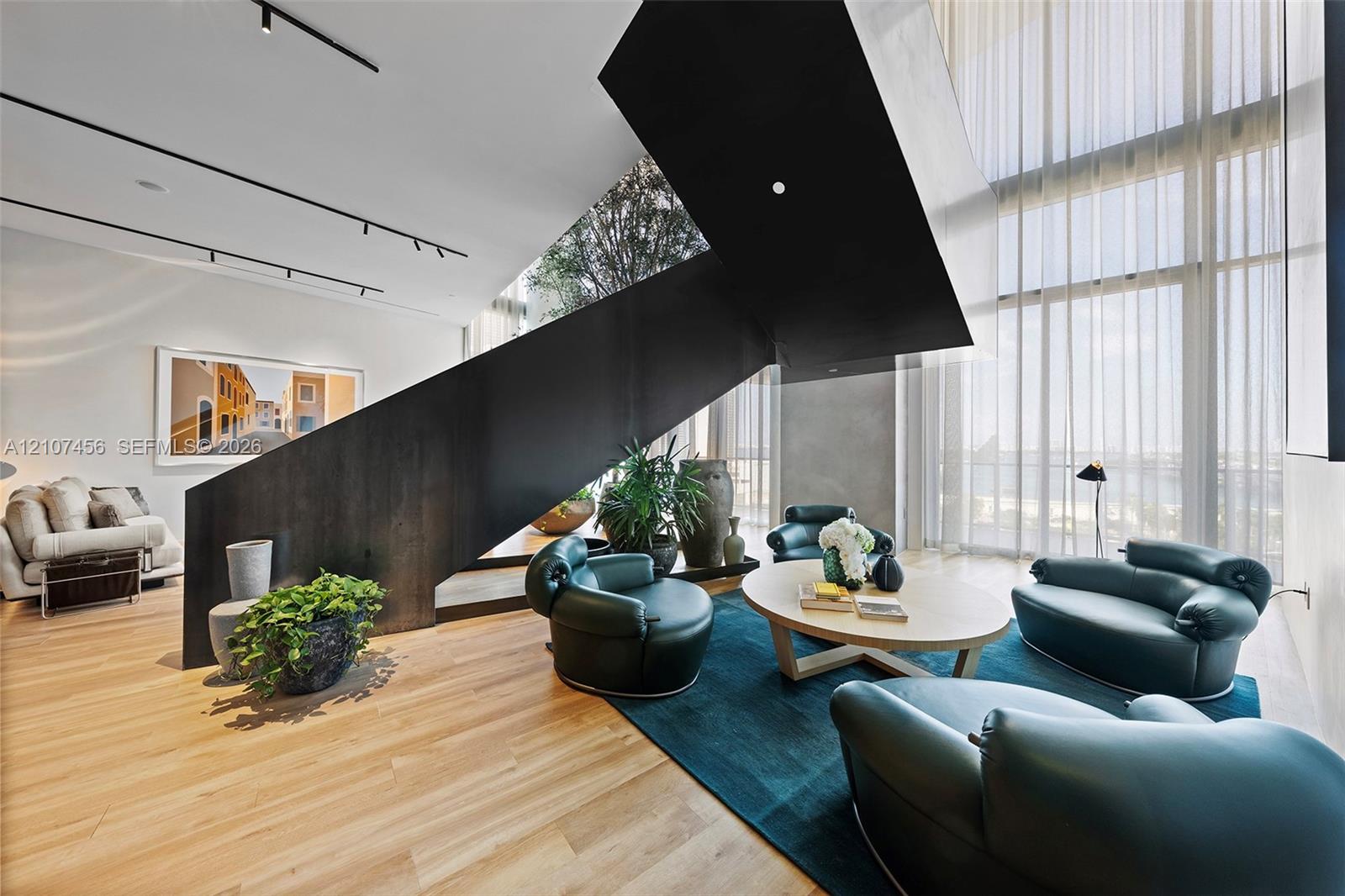 Architectural staircase with a matte black metal frame, floor-to-ceiling windows, wood-finish flooring, and recessed track lighting