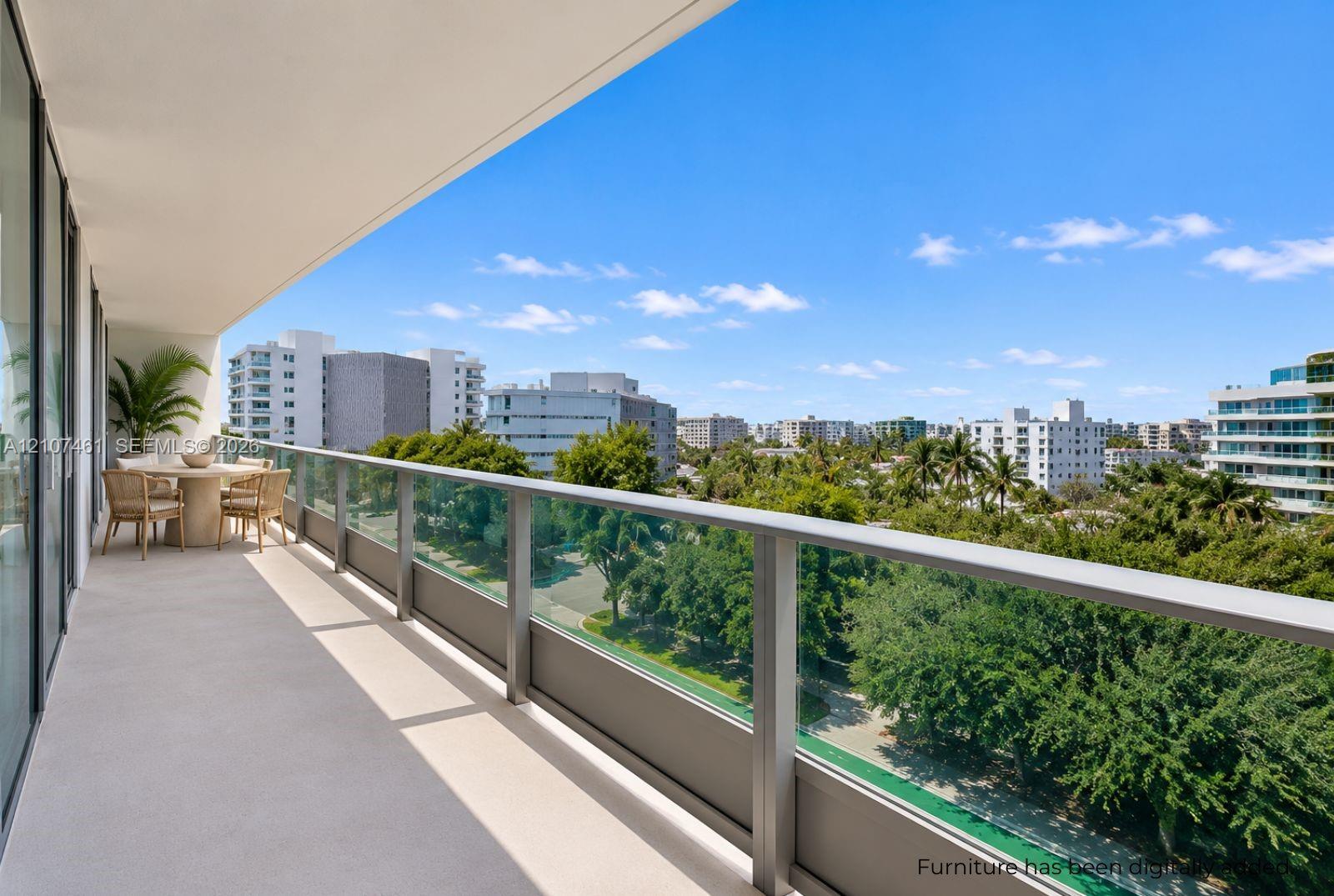 Covered balcony featuring a sleek glass railing with metal framing and concrete flooring