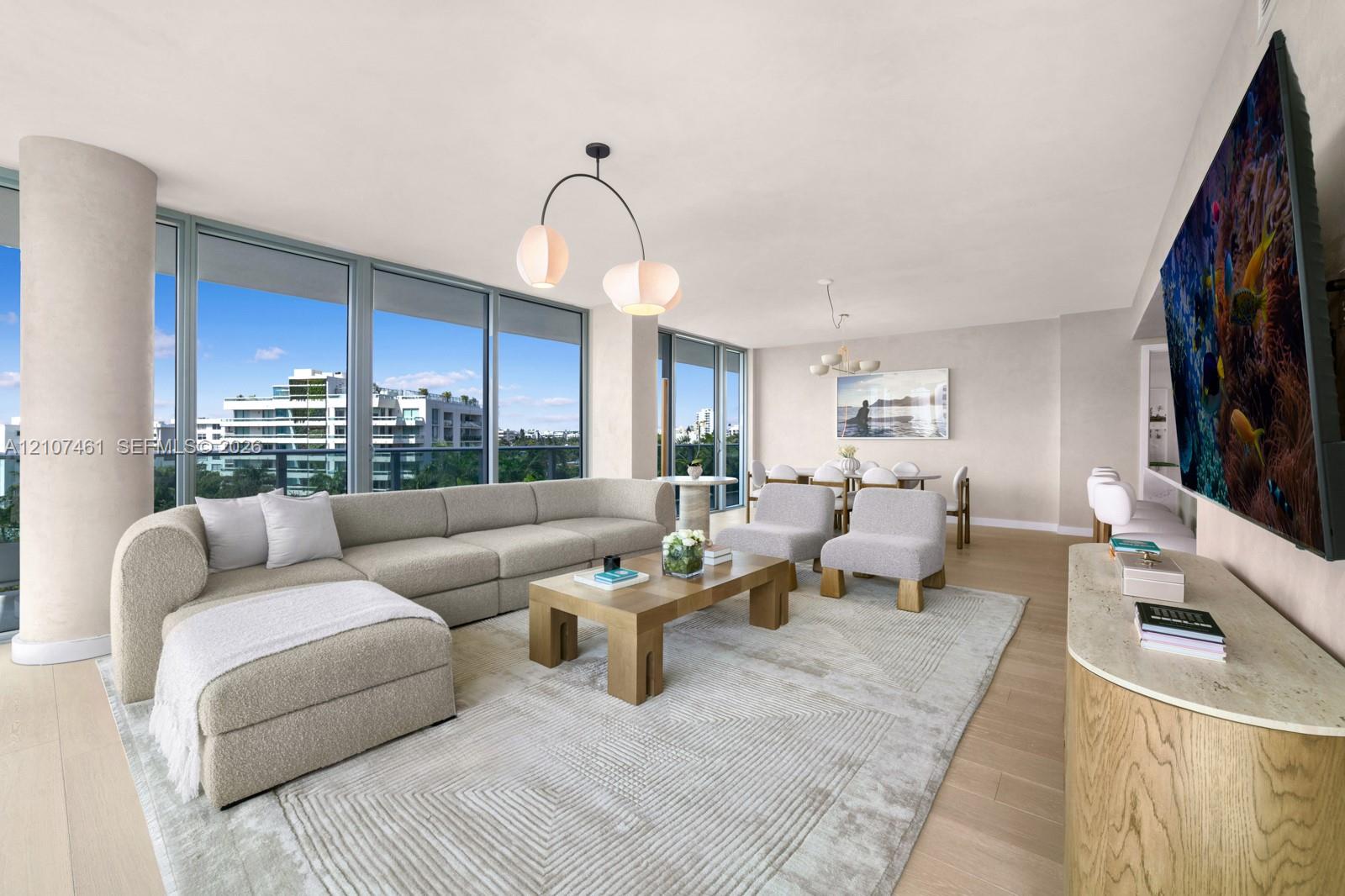 Open-concept living space featuring floor-to-ceiling windows, wood-finish flooring, a structural concrete pillar, and modern overhead globe lighting