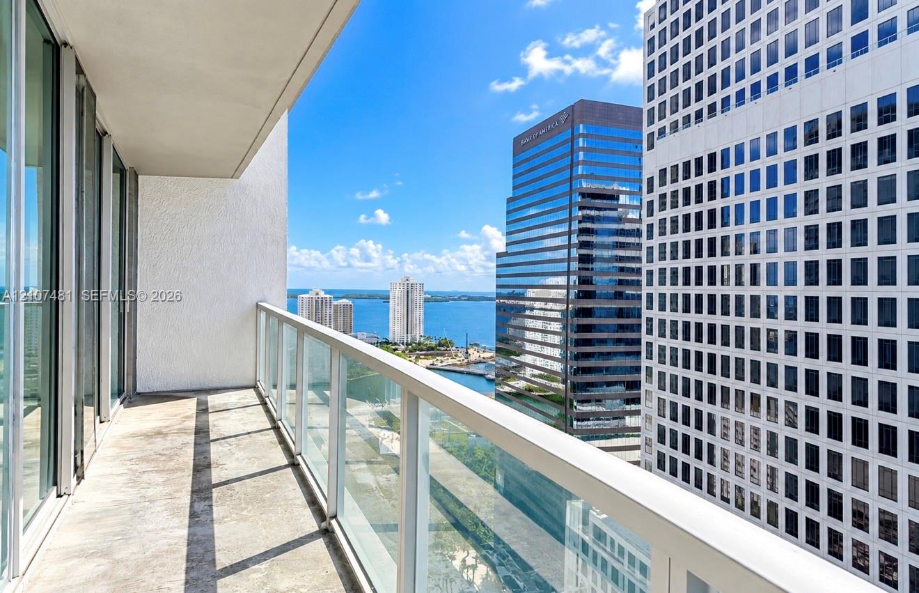 Covered balcony with glass panel railing and concrete flooring