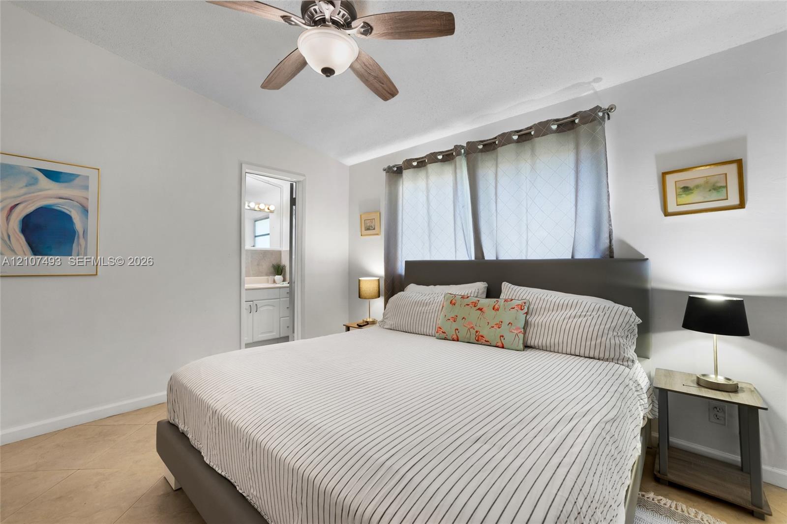 Neutral interior featuring tile flooring, a multi-blade ceiling fan with integrated lighting, and horizontal window treatments