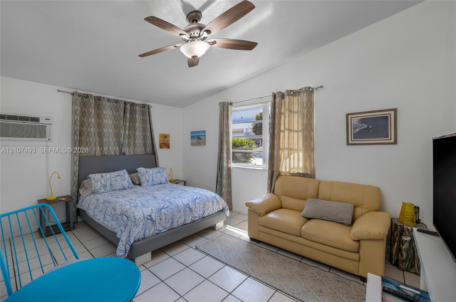 Room featuring white tile flooring, a multi-blade ceiling fan with integrated lighting, and dual windows