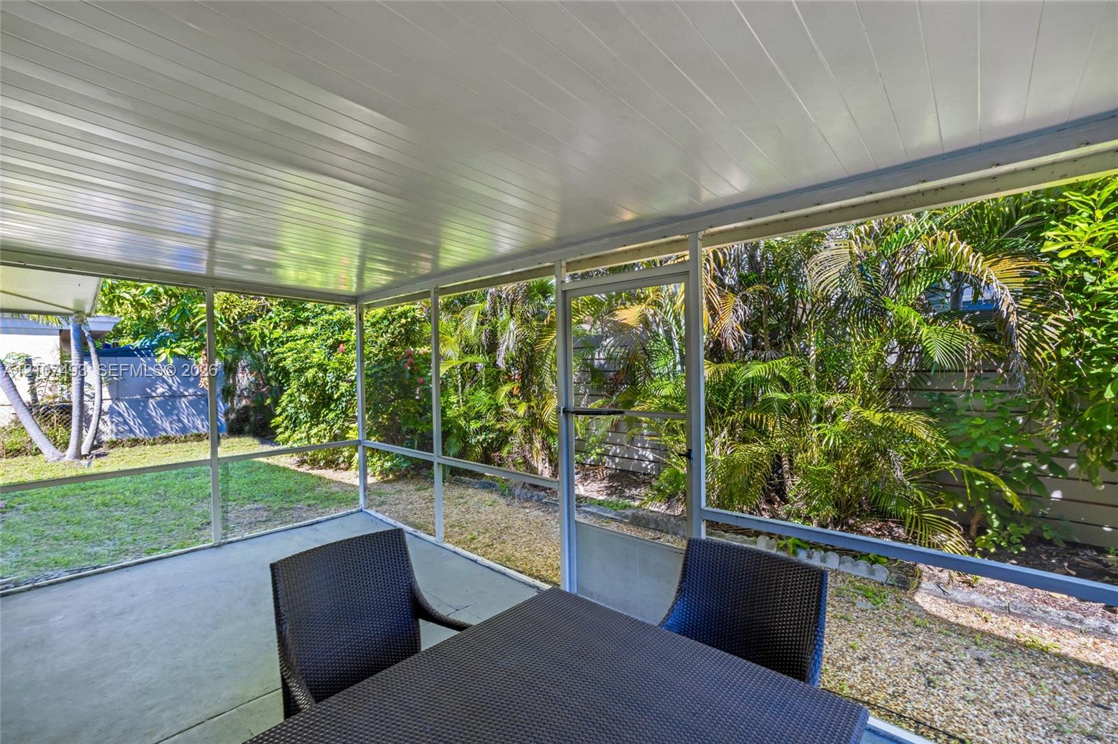 Screened-in patio featuring a concrete floor, white tongue-and-groove ceiling, and a full-height screen enclosure