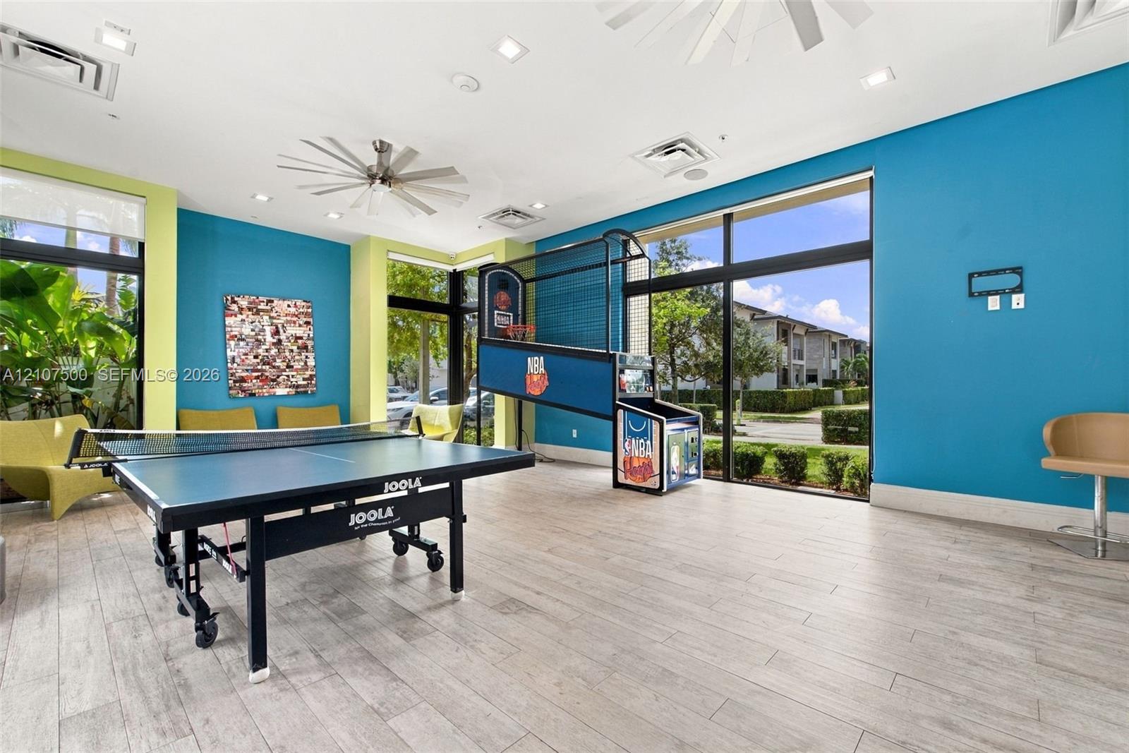 Recreation space featuring wood-finish flooring, recessed lighting, ceiling fans, and floor-to-ceiling windows
