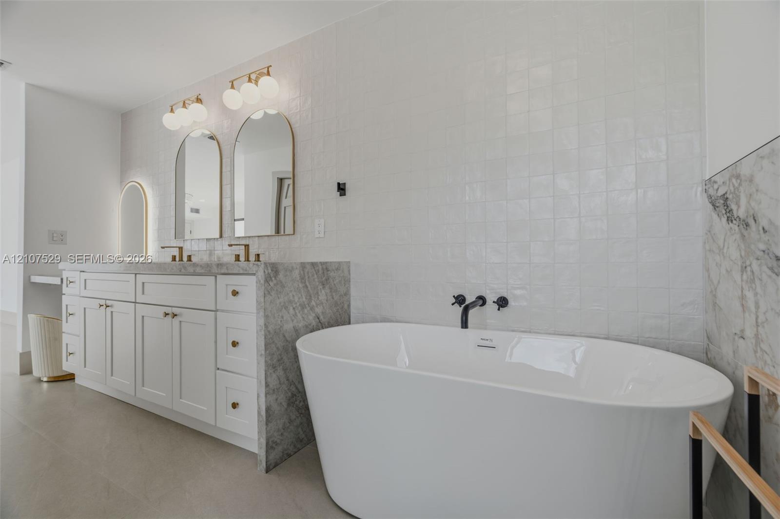Walk-in shower featuring natural stone-finish wall tile, pebble-tiled flooring, a built-in bench, and matte black rain showerhead and handheld fixture