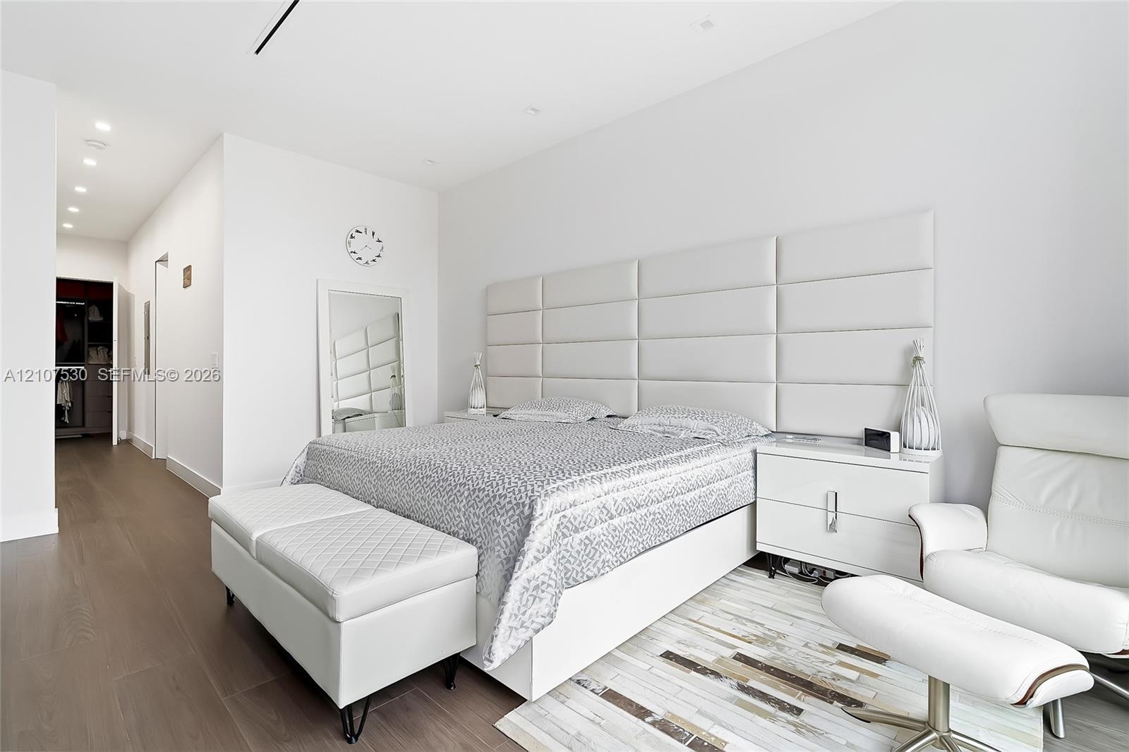 Wood-finish flooring, recessed lighting, and a large-scale, integrated paneled headboard