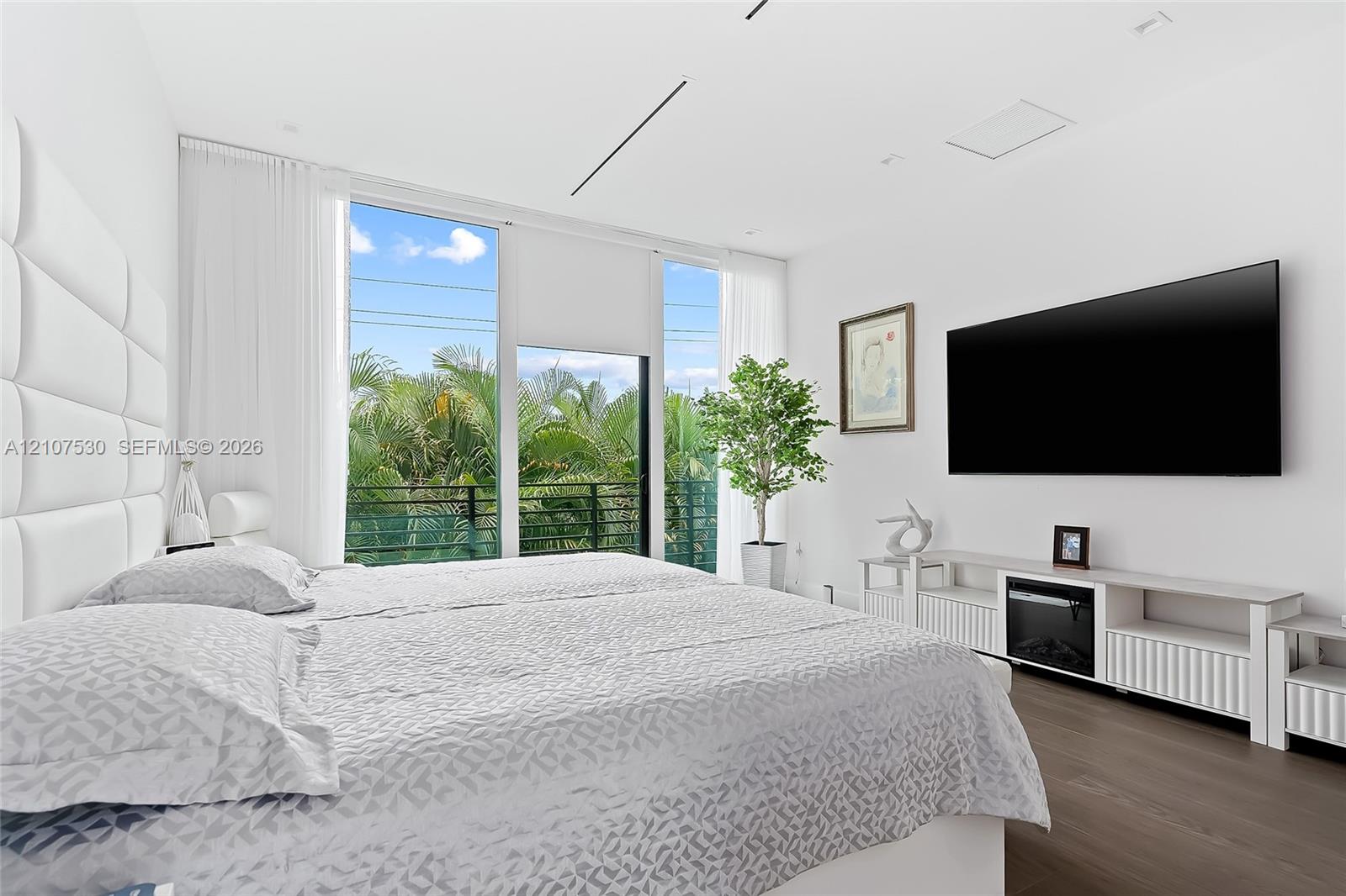 Floor-to-ceiling windows, wood-finish flooring, recessed lighting, and wall-mounted electrical fireplace