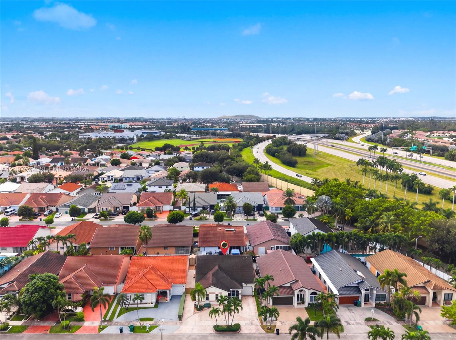 Aerial perspective of residential properties featuring varied roof pitches, concrete driveways, and mature landscaping