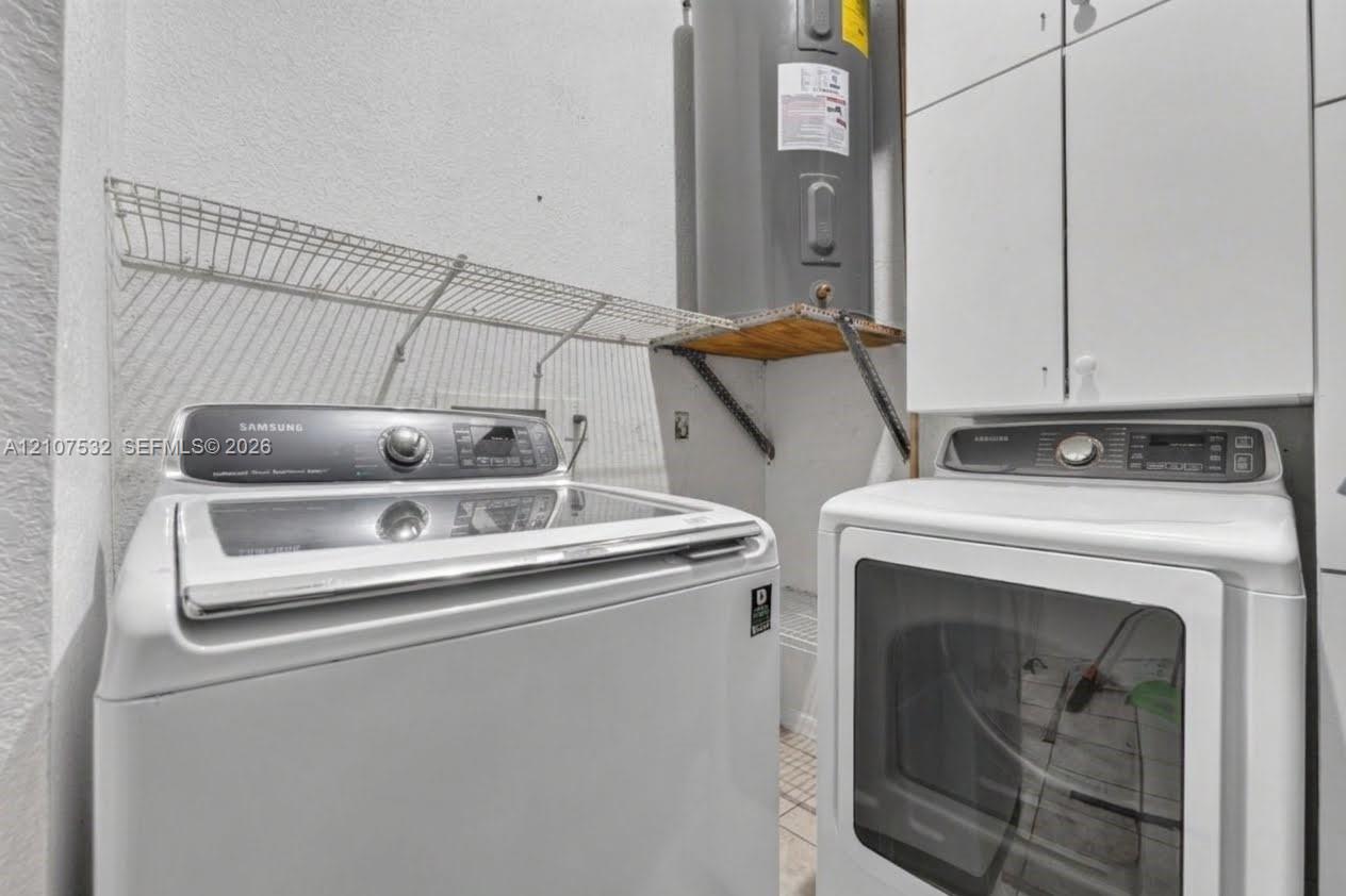 Utility area featuring white built-in cabinetry, wire shelving, and a water heater