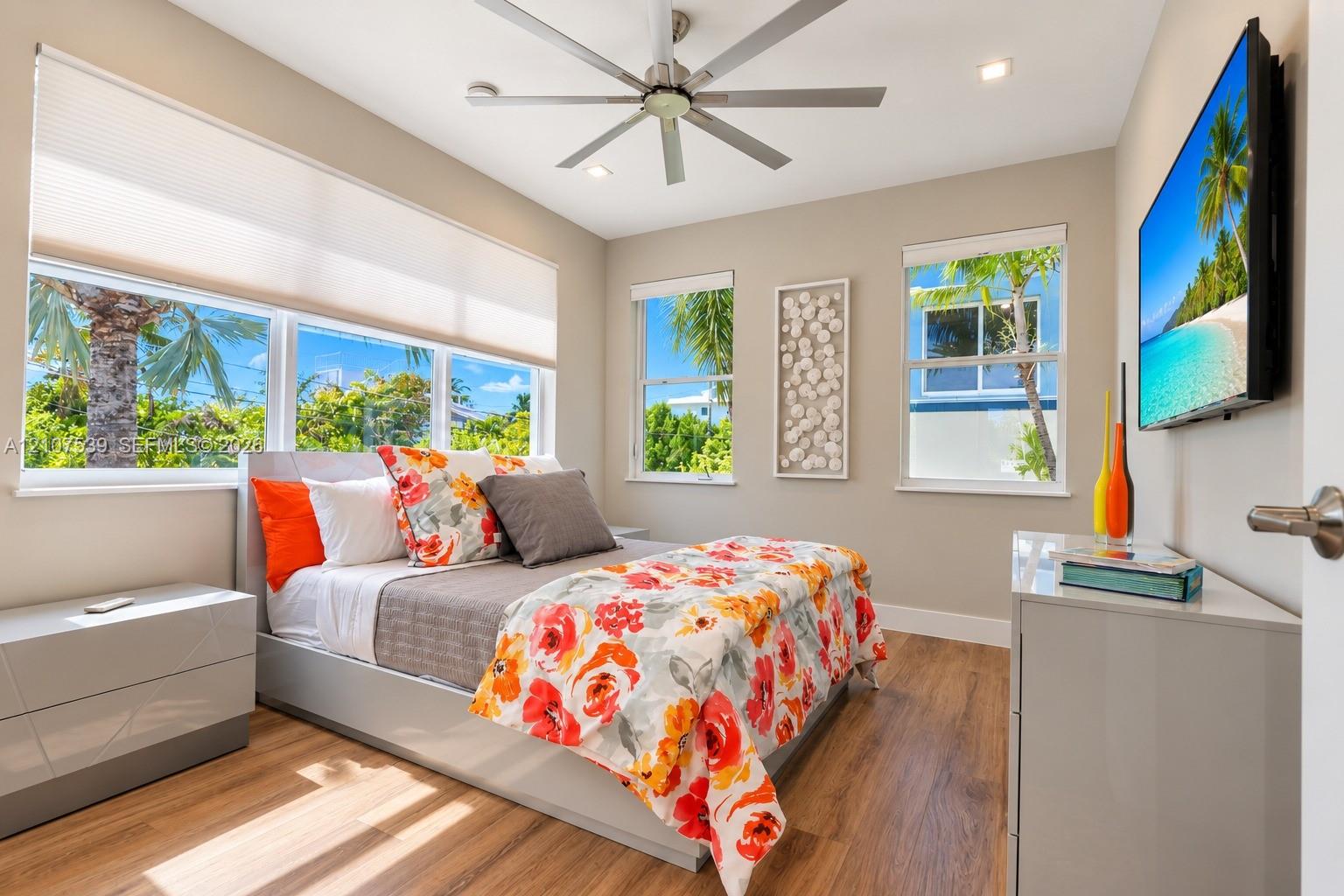 Wood-finish flooring, multi-pane windows with integrated blinds, ceiling fan, and recessed lighting