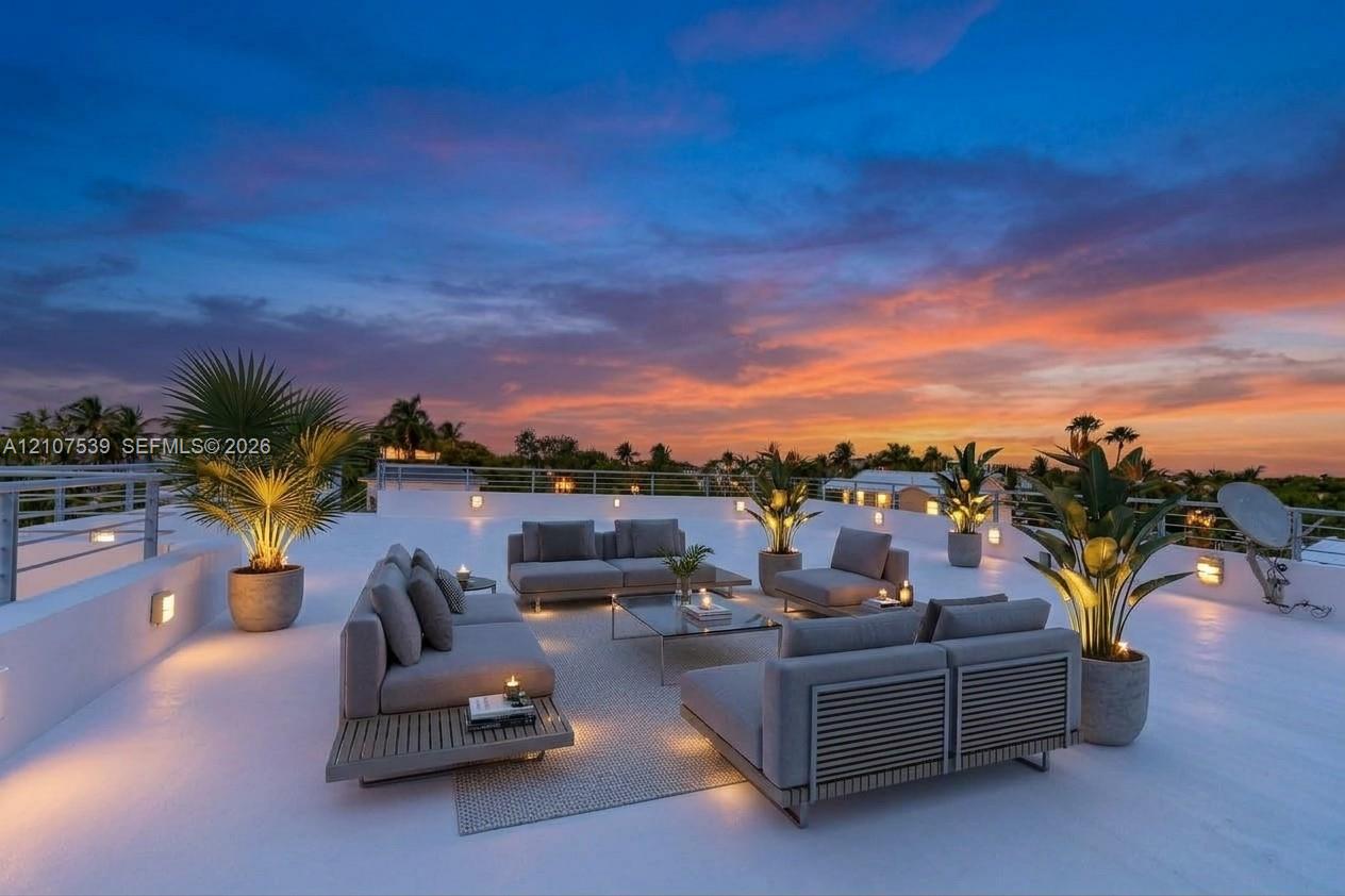 Expansive rooftop terrace featuring a smooth-finish deck, metal perimeter railing, and integrated wall-mounted lighting Expansive rooftop terrace featuring a smooth-finish deck, metal perimeter railing, and integrated wall-mounted lighting