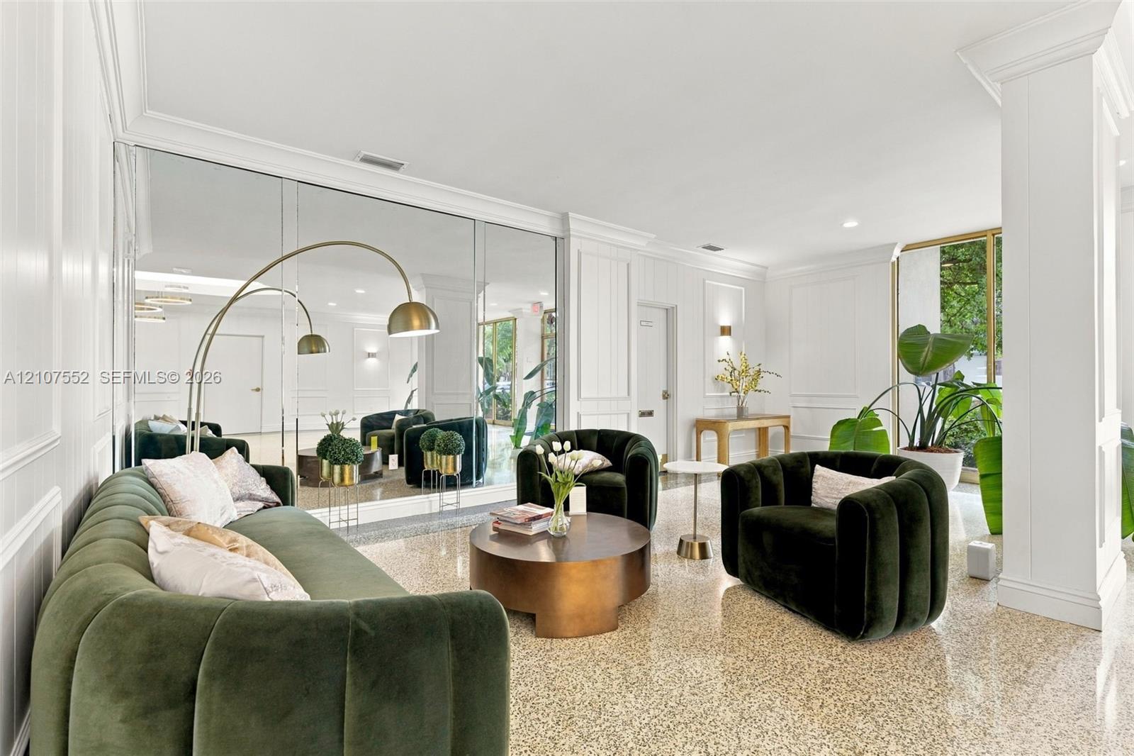 Polished terrazzo flooring, floor-to-ceiling mirror wall, architectural column, recessed lighting, and wall paneling