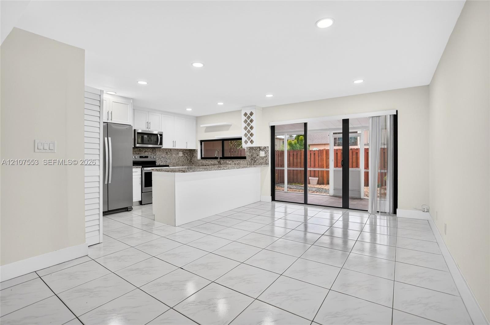 Kitchen featuring white cabinetry, stone-surface countertops, stainless steel appliances, recessed lighting, and tile flooring