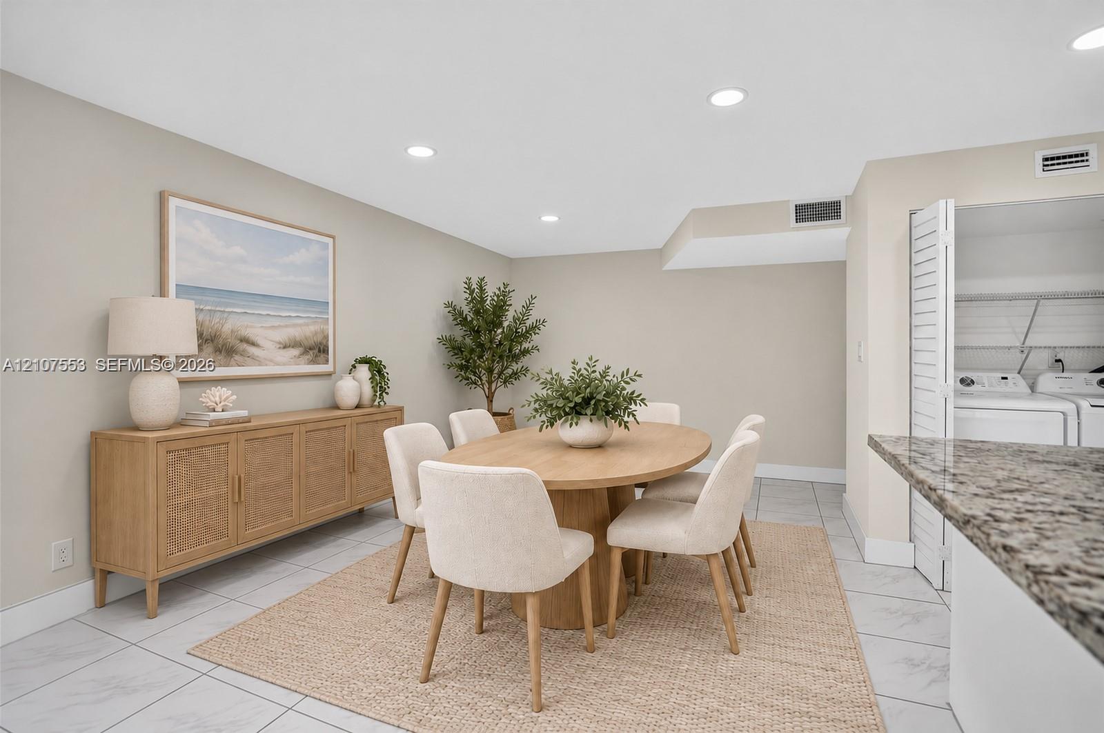 Neutral-toned interior featuring recessed lighting, large-format tile flooring, and a dedicated laundry area concealed by louvered closet doors