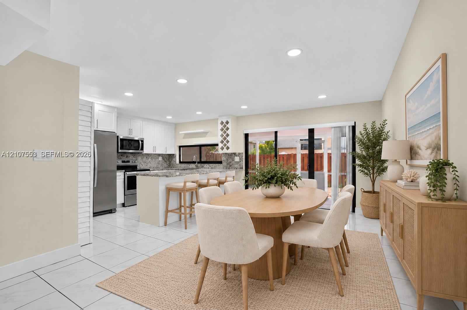 Kitchen featuring white shaker-style cabinetry, stone-finish countertops, stainless steel appliances, a built-in wine rack, and tile flooring