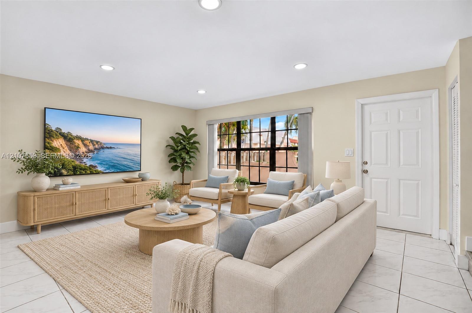 Living area featuring large-format tile flooring, recessed lighting, and multi-pane windows with dark frames