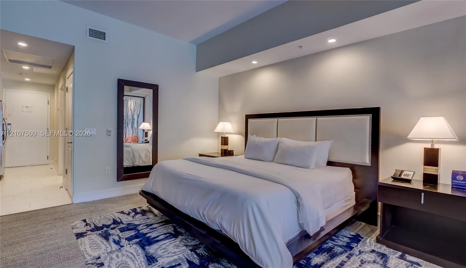High ceilings with recessed lighting, neutral wall finishes, and wall-to-wall carpeting