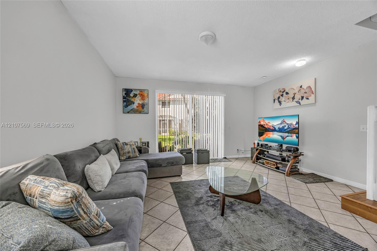 Living area featuring diagonal tile flooring and glass sliding doors