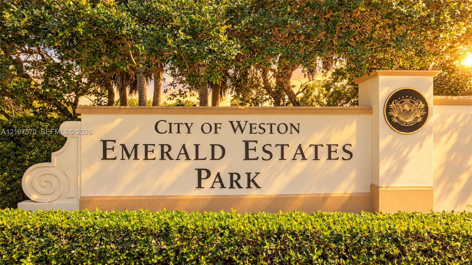 Stucco monument sign featuring raised lettering, integrated decorative medallion, and professional landscaping