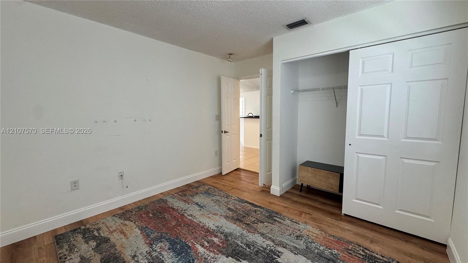 Wood-finish flooring, six-panel interior doors, and a double-door closet with built-in shelving