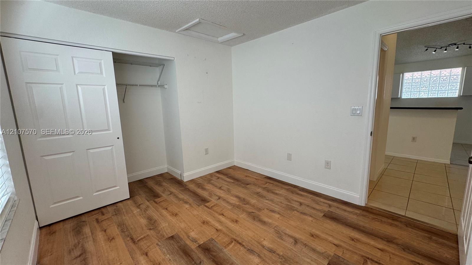 Room featuring wood-finish flooring, a sliding bi-fold closet door, and a walk-in doorway