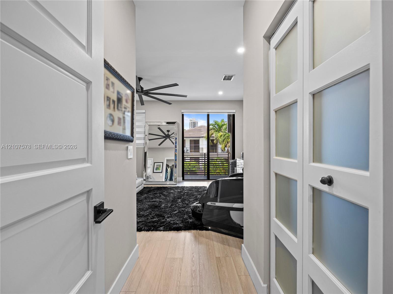 Entry featuring wood-finish flooring, paneled interior doors, and a closet with frosted glass inserts