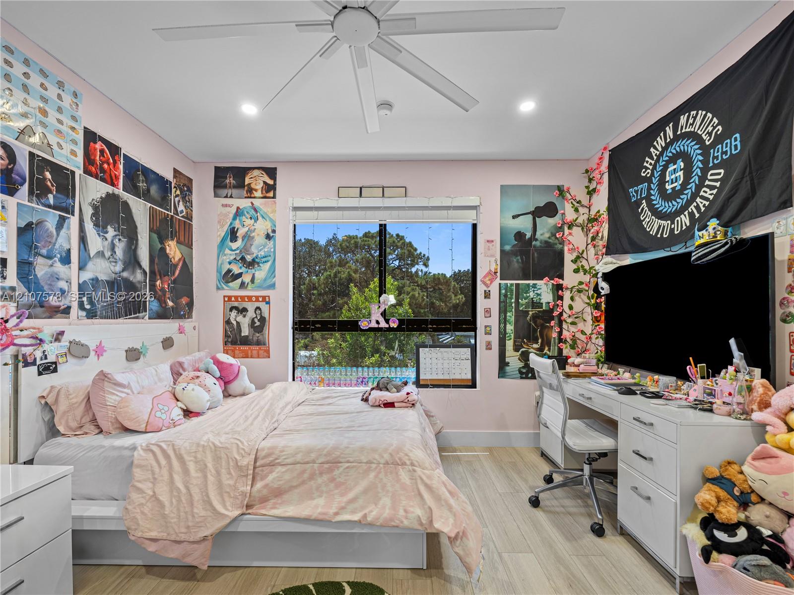 Bedroom featuring wood-finish flooring, a contemporary ceiling fan, recessed lighting, and a window with exterior scenery