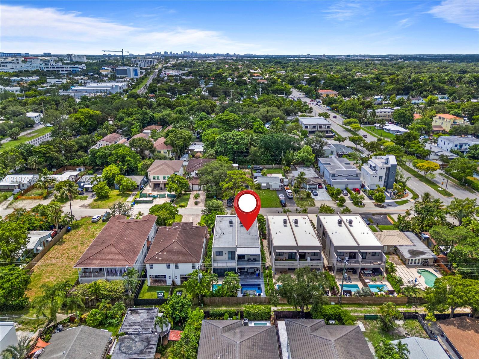 Multi-story residential structure featuring a flat roofline, attached balconies, private swimming pool, and dedicated hardscaped surface area