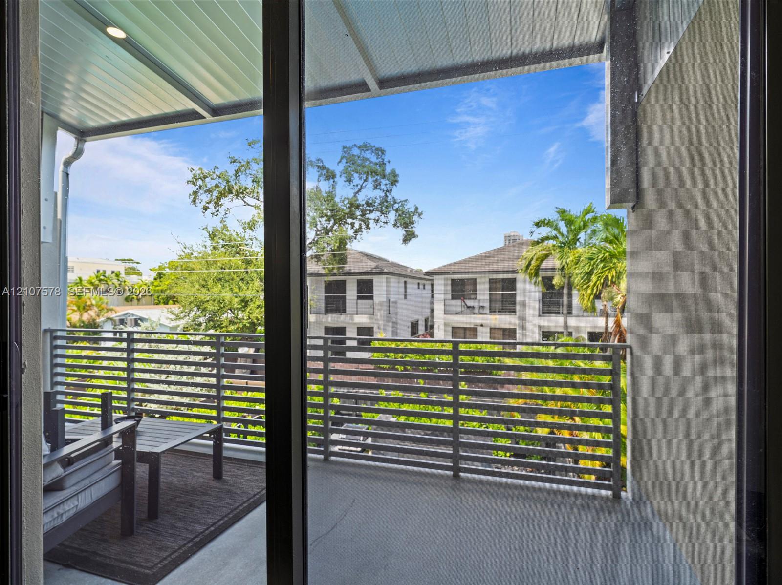 Covered balcony featuring a metal horizontal-slat railing, concrete flooring, and a recessed ceiling light