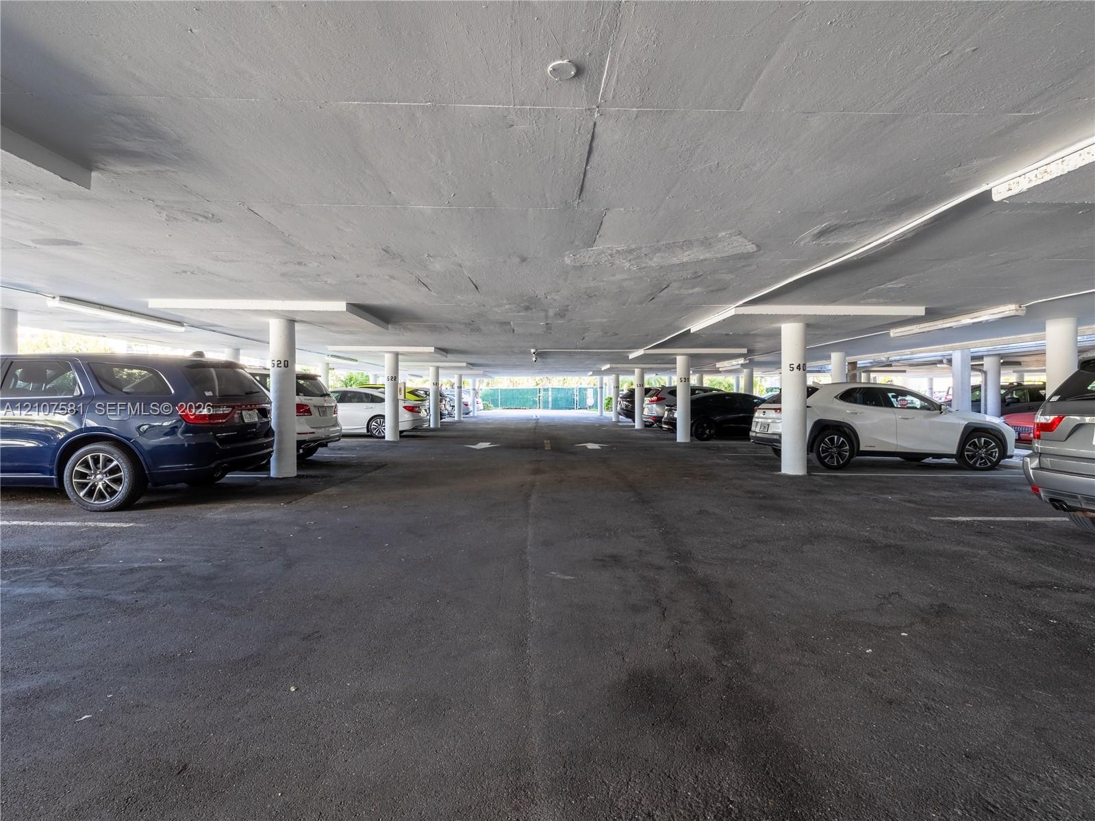Covered parking structure featuring concrete flooring and integrated lighting