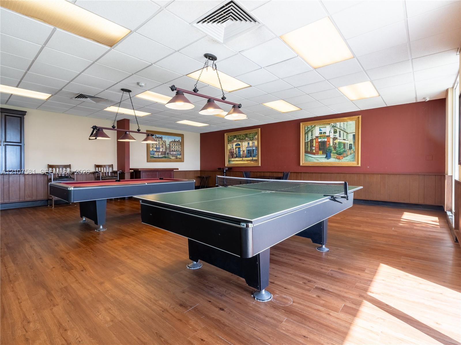 Recreation room featuring wood-finish flooring, a billiard table, a ping pong table, and track lighting
