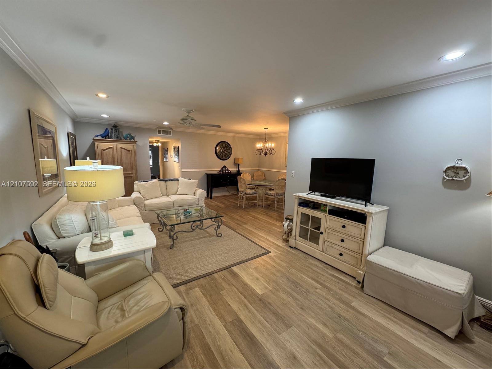 Open-concept interior featuring wood-finish flooring, crown molding, and recessed lighting Open-concept interior featuring wood-finish flooring, crown molding, and recessed lighting