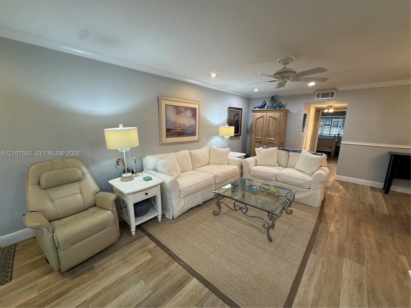 Wood-finish flooring, recessed lighting, ceiling fan, crown molding, and chair rail trim Wood-finish flooring, recessed lighting, ceiling fan, crown molding, and chair rail trim