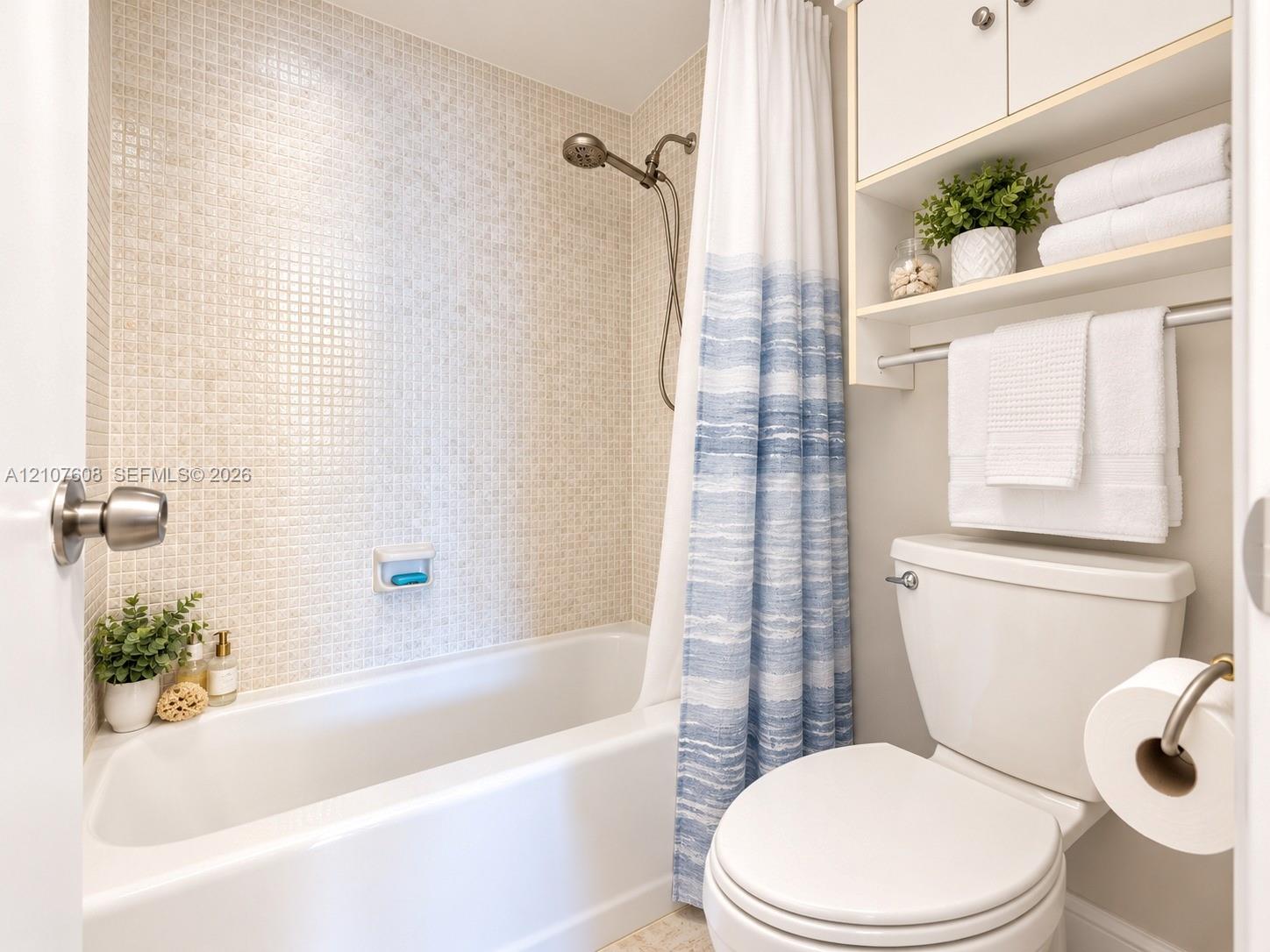 Full-height tiled shower surround, integrated wall-mounted cabinetry with open shelving, chrome shower fixtures, and porcelain tub