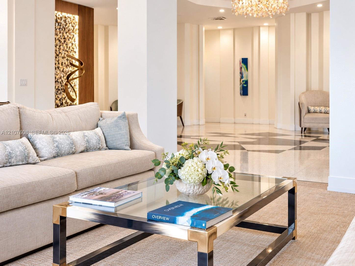 Spacious interior featuring geometric patterned stone flooring, vertical wall paneling, integrated recessed accent lighting, and a crystal chandelier