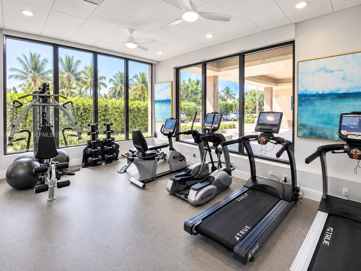 Fitness center featuring floor-to-ceiling windows, recessed lighting, ceiling fans, and durable flooring